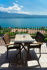 Balcony with table and chairs with view on Garda Lake in Gargnano in Italy