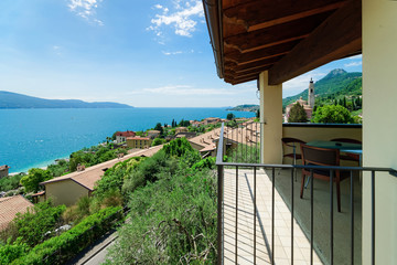 Fototapeta na wymiar Terrace with table and chairs with view on Garda Lake on Italy