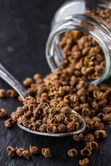 Sichuan pepper on a dark stone background