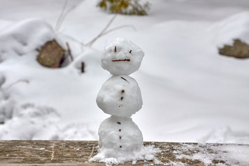 Tiny snowman on a railing of a wooden bridge in Olczyska Valley in Tatra Mountains, Poland