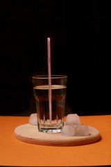 A glass of water with ice and a straw