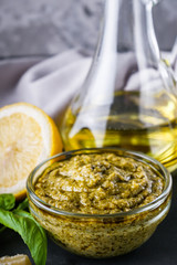 Delicious traditional italian pesto sauce on dark stone background