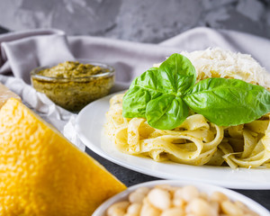 Delicious tagliatelle pasta with pesnto sauce on dark stone background