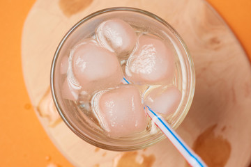 A glass of water with ice and a straw