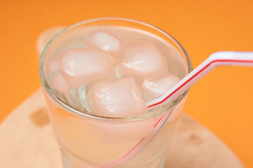 A glass of water with ice and a straw