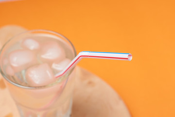 A glass of water with ice and a straw