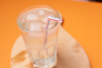 A glass of water with ice and a straw