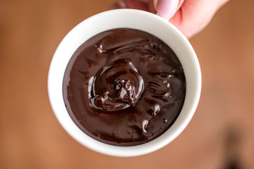 Hot chocolate in a cup, dark styled photo, top view.