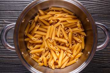 traditional italian pasta in a metal pan on a wooden background