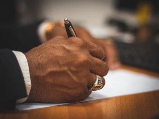hand with a pen signing documents