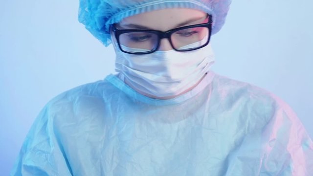Clinical treatment. Rescue emergency care. Female surgeon in PPE performing operation.