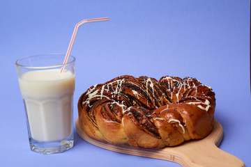 Braided roll with poppy seeds and cinnamon on yellow background. Top view