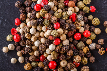 mix of peppercorns on a dark stone background