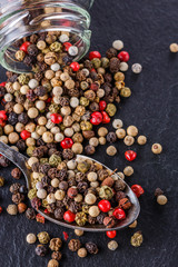mix of peppercorns on a dark stone background