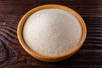 natural organic semolina on dark wooden rustic background