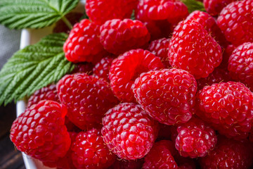 juicy fresh natural raspberries on a dark wooden rustic background