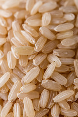 raw brown rice on white acrylic background
