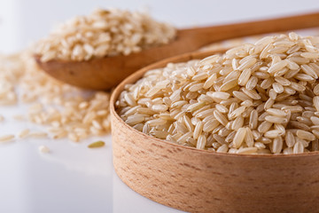 raw brown rice on white acrylic background