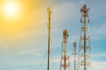 Various telephone signal repeater communication towers with bright sunny sky 