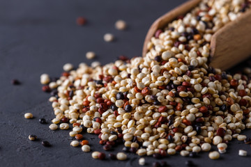 mix of quinoa grains on a dark stone background