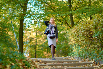 Beautiful young woman is walking in the park. Young woman enjoying nature