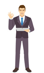 OK! Smiling Businessman show a okay hand sign and holding digital tablet PC. Full length portrait of Businessman in a flat style. Vector illustration.