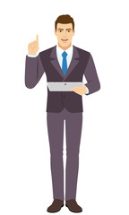 Smiling Businessman holding digital tablet PC and pointing up. Full length portrait of Businessman in a flat style.