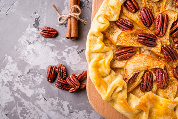 crispy apple galette with pecans on a rustic wooden background