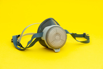Respirator with interchangeable filter cartridges. Isolated on yellow background. Close-up.