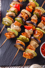 chicken kebabs with vegetables and mushrooms on a rustic background