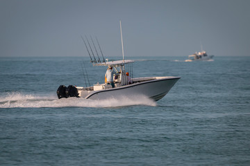A sport fishing boat races to the next location to make the catch of the day.