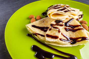 crepes with banana and chocolate spread on a green plate