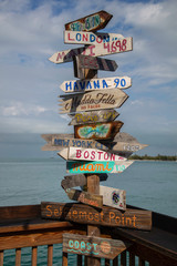 A guidepost sign near Mallory Square in Key West, Florida indicates the direction to other cities...