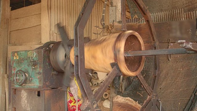 Workers forming long drum By using a rotating motor and using sharp object for forming