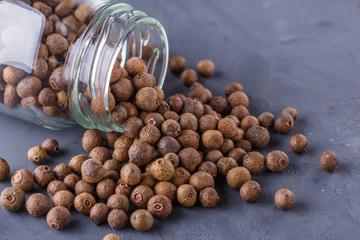 fresh spicy peppers allspice on a dark stone background
