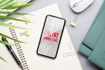 Online Marketing Advertising Branding Commerce Concept. Mockup smart phone with Online Marketing word on screen, Mock up mobile phone Flat lay top view.