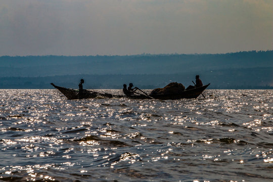 Silhouette of fisherman out for the day to cast their nets on southern edge of Lake Victoria in Kenya