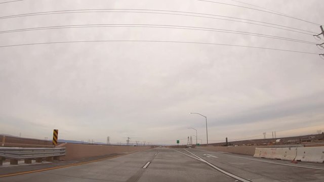 Mojave, United States - December 02, 2019: 4K. POV view of car driving on highway in the California states. A car drives on a freeway. Asphalt with yellow line at new road. Mojave desert.