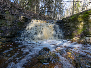 spring landscape with a small waterfall on a small wild river