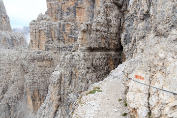 Rock ledge of via ferrata Sentiero delle Bocchette Centrale and mountain alps panorama in Brenta...