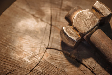 Iron hammer on a wooden stump.