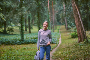 Beautiful young woman walks in the park