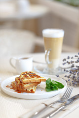 Fried Belgian waffles, dessert on the table in the restaurant in the style of Provence
