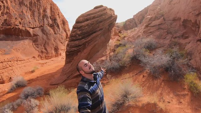 Valley of Fire, United States - December 02, 2019: 4K. Slow motion of a young man breathing deeply in a natural park of the Valley of Fire to enjoy of nature. Sunny day.