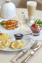 Delicious culinary dishes, desserts, ice cream, waffles and pancakes on the table in the restaurant in the style of Provence
