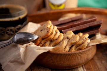 Homemade chocolate chip cookie. Baking, sweet snack. Food on a wooden table. Rustic style. Cooking at home. Chocolate for coffee.