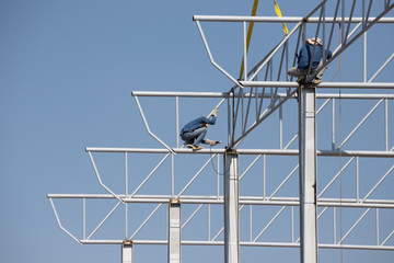 installation steel roof and structure. worker welding the steel truss of roof.