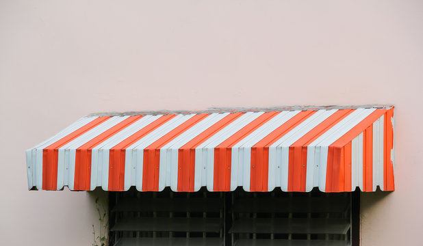 white and orange striped metal awning over resident window.