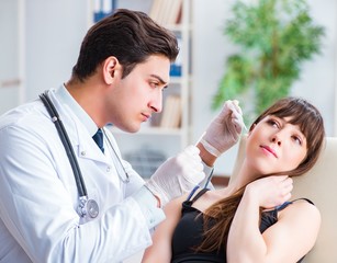 Doctor checking patients ear during medical examination