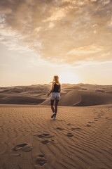 Fototapeta na wymiar Woman walking in the desert